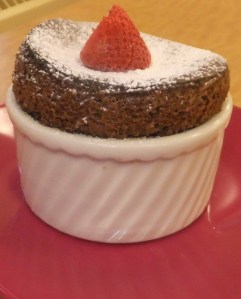 Soufflés will fall a little bit (cracking the tops) once they're taken out of the oven, but they really should remain fairly puffy.