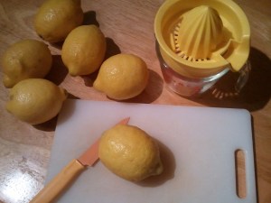 Get together your lemons, juicer or reamer, knife, and cutting board.
