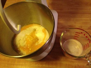 The flour, salt, milk, yolks, and oil are in the mixing bowl, and the yeast and water are getting cozy in the measuring cup.
