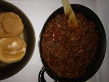 Meat mixture simmering in one skillet, buns toasting in another.