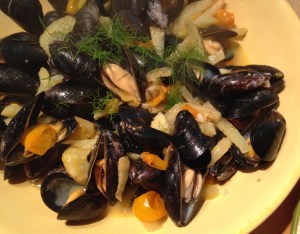 Use a ladle to scoop up a number of mussels (with their shells) and broth.
